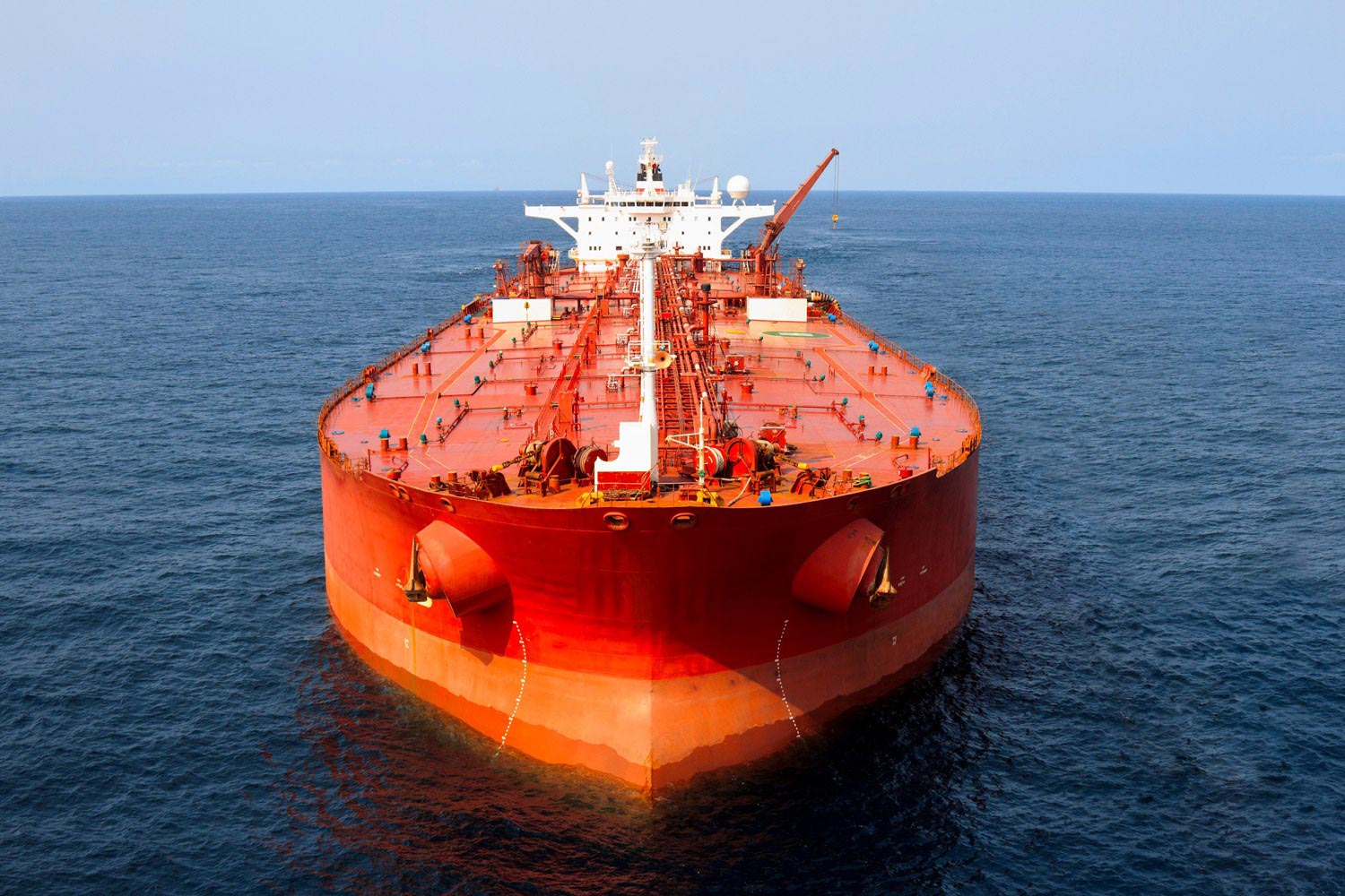 Red and white cargo ship from the front